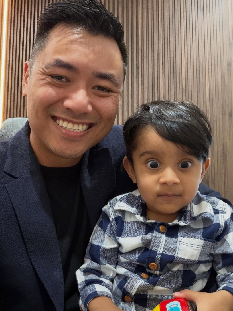 Dr Lam with a toddler in a checked shirt at his check-up